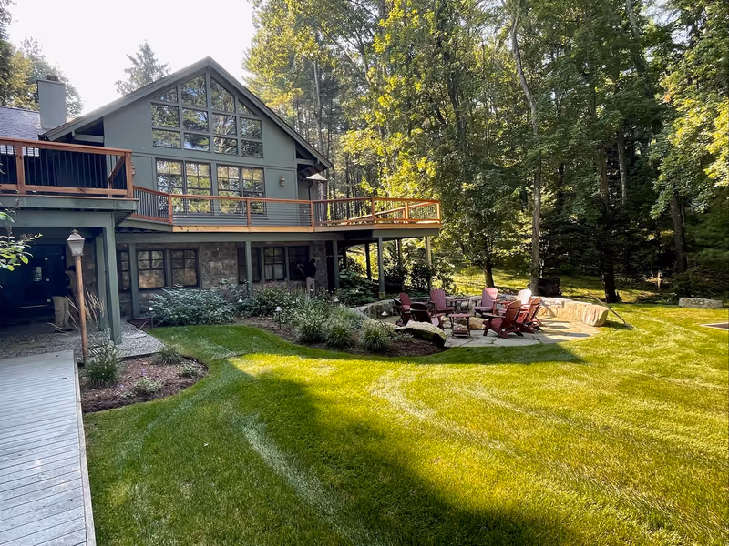 Maintained lawn around a residence with an outdoor seating area.