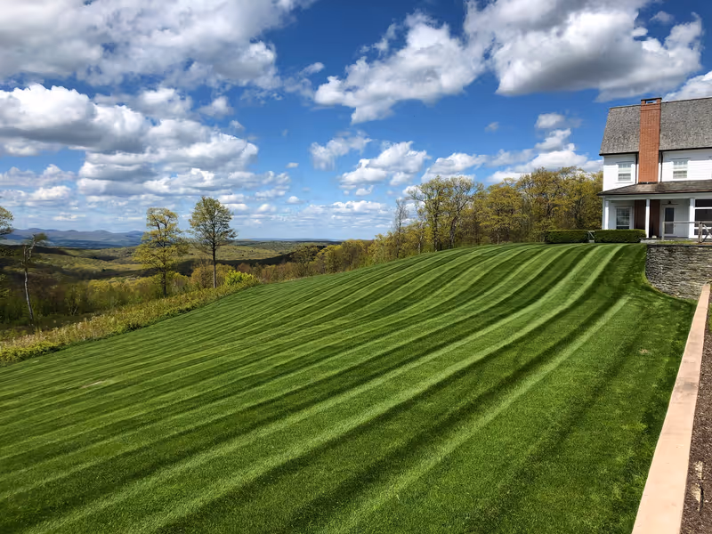 Striped estate lawn extending toward an open rural view.