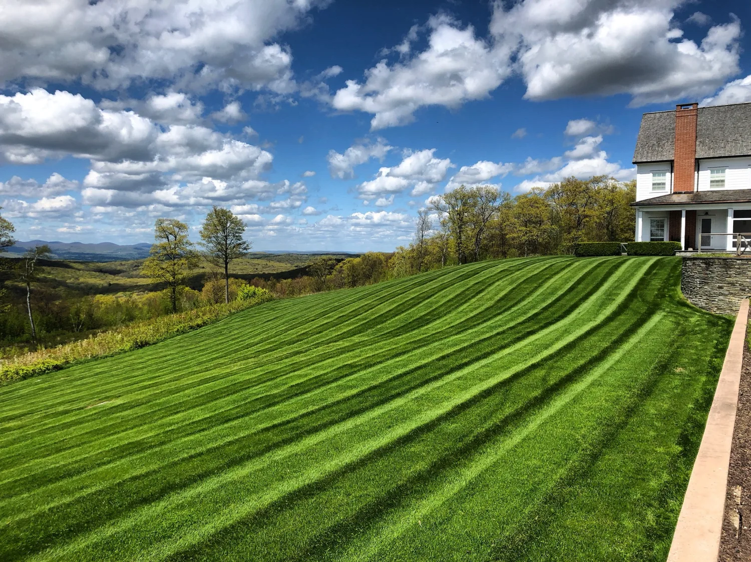 Estate maintenance service area with crisp lawn, beds, and property presentation.