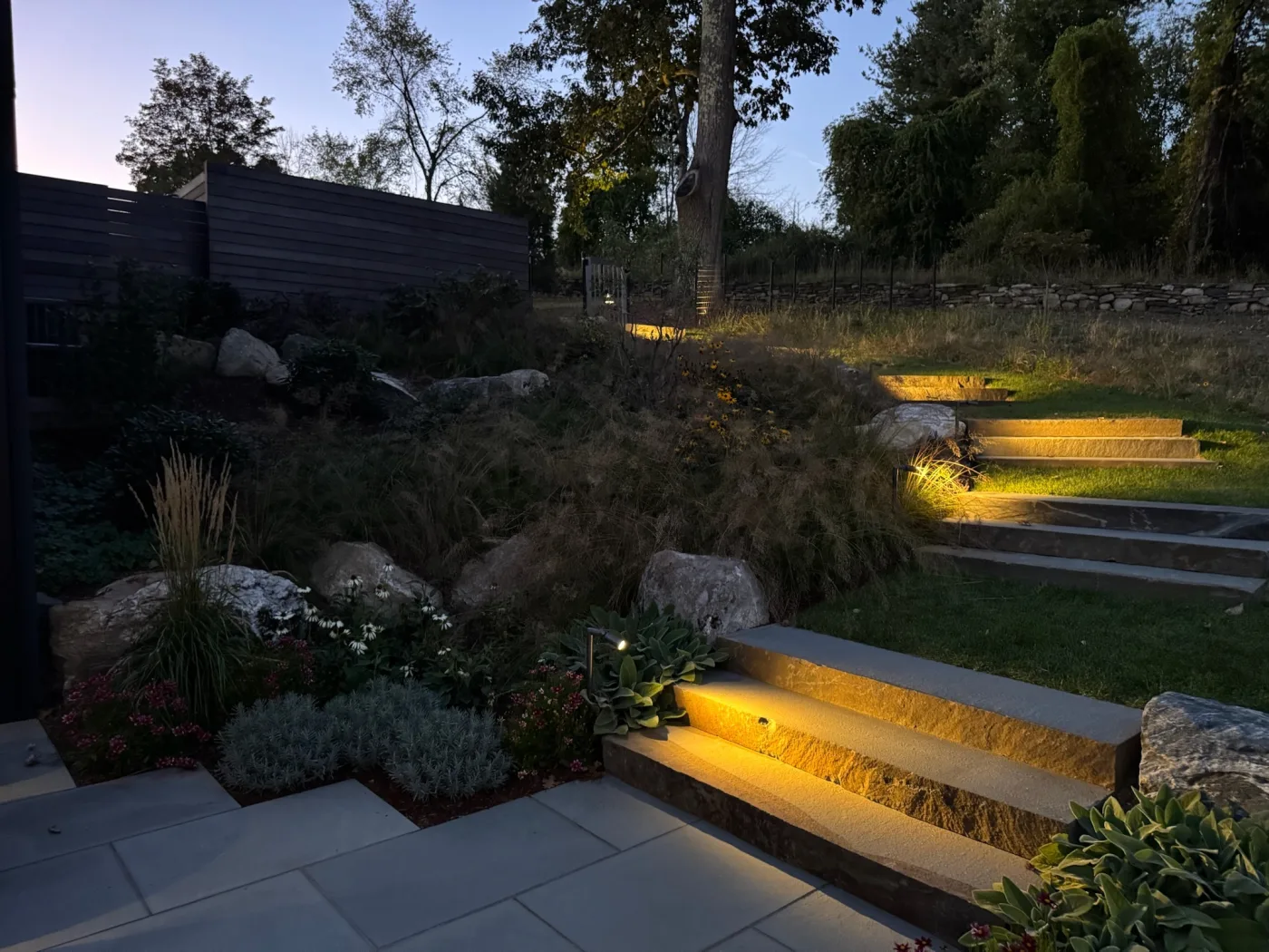 Evening patio and landscape lighting work with illuminated outdoor living area.