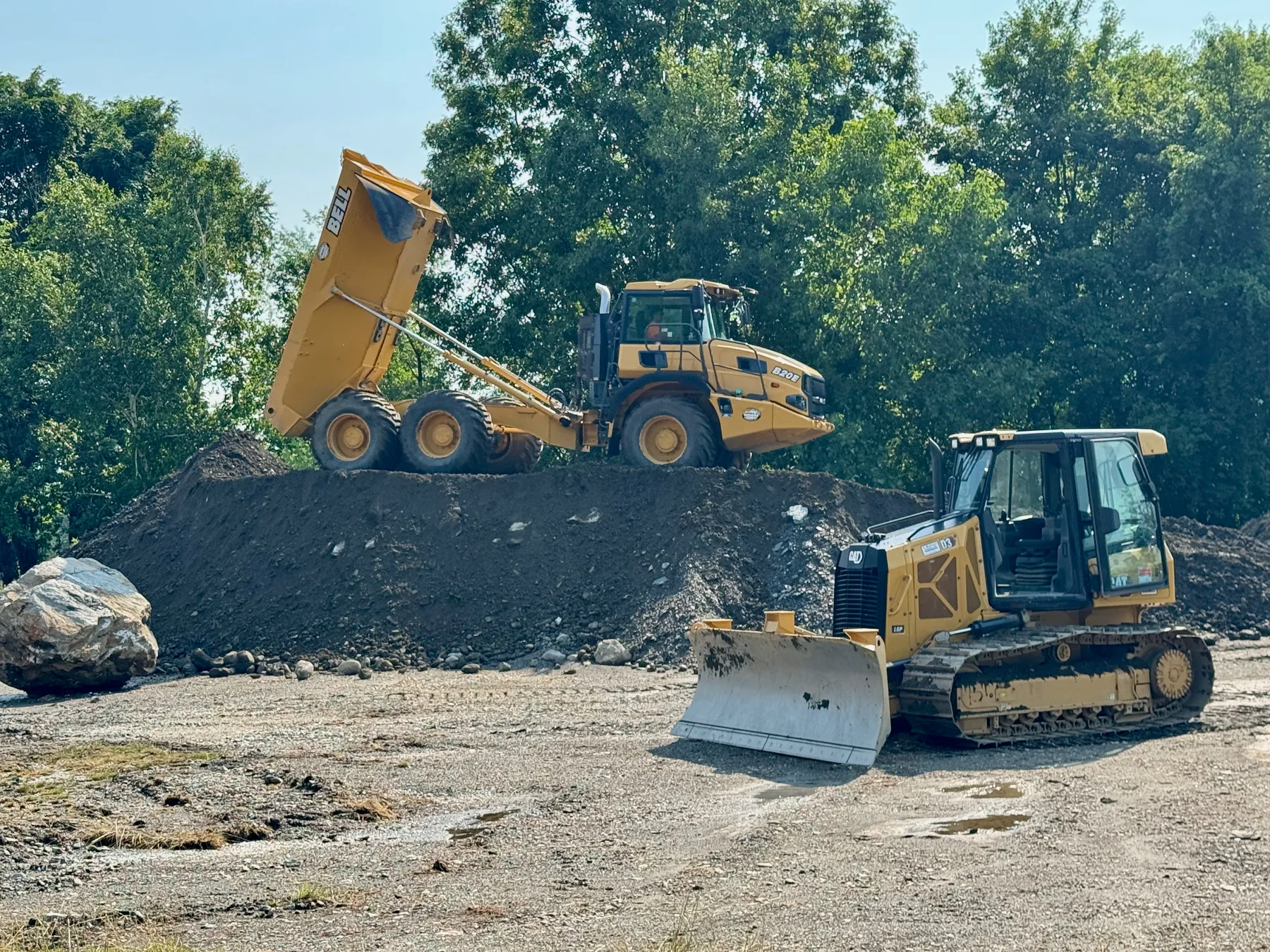 Heavy equipment moving earth during excavation and site preparation.