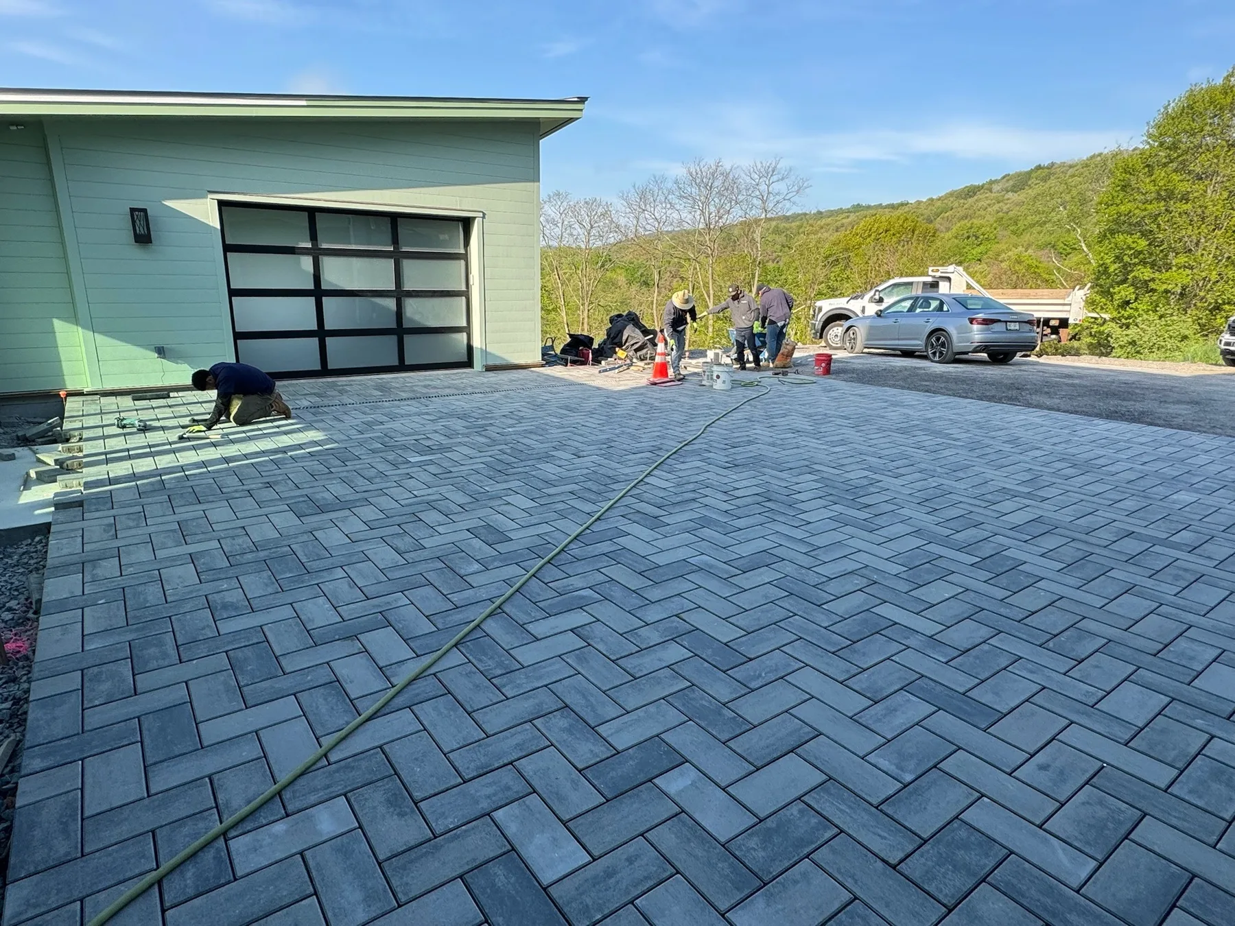 Paver driveway and courtyard installation in progress at a residential property.